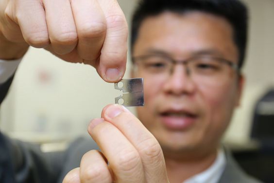 Professor Huang Mingxin shows a thin light piece of super steel which demonstrates a ultra high level of fracture resistance, strength and ductility.   