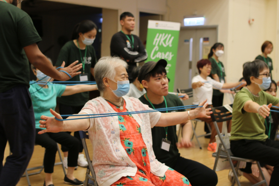 The student ambassadors coach elderlies to practice resistance band exercises.